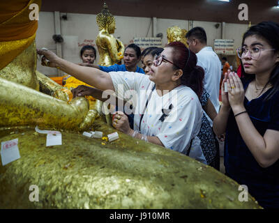 Chachoengsao, Thaïlande. 31 mai, 2017. Les femmes s'appliquer de la feuille d'or d'une statue de Bouddha de Wat Sothon (également orthographié Sothorn) dans Chachoengsao, Thaïlande. Le temple est l'un des plus grand et le plus visité en Thaïlande. Les gens font le mérite en payant pour envelopper les statues de Bouddha en robe jaune. Le temple est le plus connu parce que les gens quittent oeufs durs comme une offrande au temple. Ils demandent à la réussite d'une entreprise ou d'enfants et laisser des centaines d'œufs durs. Crédit : Jack Kurtz/ZUMA/Alamy Fil Live News Banque D'Images