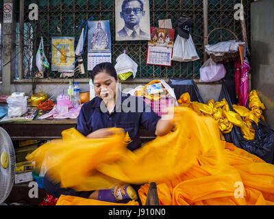 Chachoengsao, Thaïlande. 31 mai, 2017. Un travailleur roule tissu orange utilisé pour emballer les statues de Bouddha du Wat Sothon (également orthographié Sothorn) dans Chachoengsao, Thaïlande. Le temple est l'un des plus grand et le plus visité en Thaïlande. Les gens font le mérite en payant pour envelopper les statues de Bouddha en robes orange. Le temple est le plus connu parce que les gens quittent oeufs durs comme une offrande au temple. Ils demandent à la réussite d'une entreprise ou d'enfants et laisser des centaines d'œufs durs. Crédit : Jack Kurtz/ZUMA/Alamy Fil Live News Banque D'Images