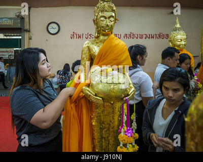 Chachoengsao, Thaïlande. 31 mai, 2017. Une femme s'enroule une statue du Bouddha en tissu orange à Wat Sothon (également orthographié Sothorn) dans Chachoengsao, Thaïlande. Le temple est l'un des plus grand et le plus visité en Thaïlande. Les gens font le mérite en payant pour envelopper les statues de Bouddha en robes orange. Le temple est le plus connu parce que les gens quittent oeufs durs comme une offrande au temple. Ils demandent à la réussite d'une entreprise ou d'enfants et laisser des centaines d'œufs durs. Crédit : Jack Kurtz/ZUMA/Alamy Fil Live News Banque D'Images