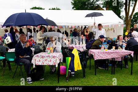 Les habitants de vous détendre dans la tente de rafraîchissements dans la pluie typiquement anglais dans un village local juste, Rowledge, UK. 29.05.2017. Banque D'Images