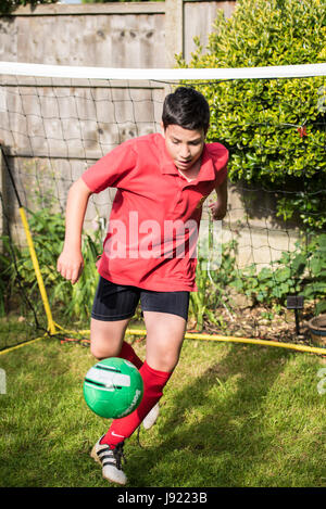 Les pratiques de soccer au garçon d'un jardin anglais Banque D'Images