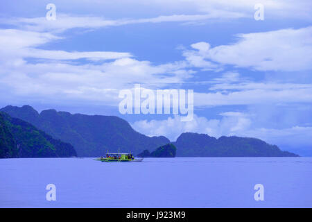 Un bateau traditionnel banka outrigger bateau dans la mer de Chine méridionale, le long de l'île de Coron dans l'Îles Calamian dans le nord de Palawan des Philippines Banque D'Images