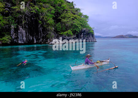 Un pêcheur dans un bateau à l'outrigger banka le sud de la Chine le long de la mer l'île de Coron dans l'Îles Calamian dans le nord de Palawan des Philippines Banque D'Images