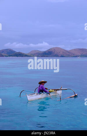 Un pêcheur dans un bateau à l'outrigger banka le sud de la Chine le long de la mer l'île de Coron dans l'Îles Calamian dans le nord de Palawan des Philippines Banque D'Images