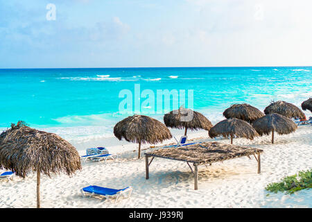 Des chaises longues et des parasols sur la plage de sable blanc de l'île des Caraïbes Banque D'Images