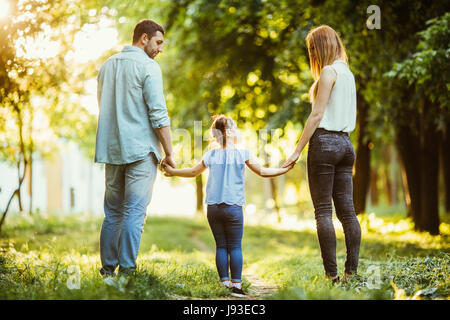 Famille Dans Le Parc Maman Papa Et Bebe Heureux A Pied Au Coucher Du Soleil Le Concept D Une Famille Heureuse Les Parents Tiennent Les Mains Du Bebe Photo Stock Alamy