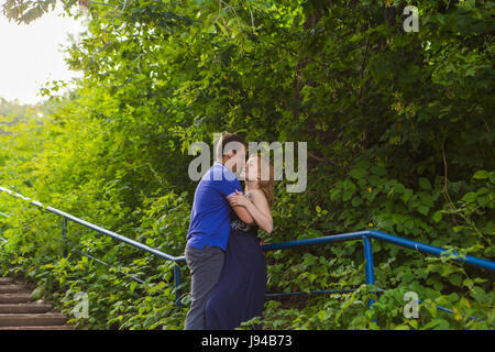 Vacances d'été, l'amour, de romance et de personnes concept - happy smiling young couple hugging outdoors Banque D'Images