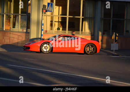 Une Ferrari roulant dans les rues le soir Banque D'Images