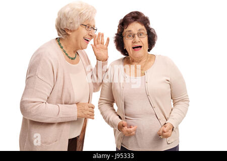 Mature Woman whispering à son ami surpris isolé sur fond blanc Banque D'Images