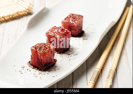 Sashimi de thon trempé dans la sauce de soja, le sel et l'aneth épais avec des baguettes et bambou. Le poisson cru de style traditionnel japonais. Image horizontale. Banque D'Images