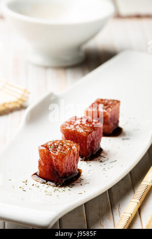 Sashimi de thon trempé dans la sauce de soja, le sel et l'aneth épais avec des baguettes et bambou. Le poisson cru de style traditionnel japonais. Vertical image. Banque D'Images