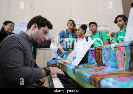 (170605) -- NEW YORK, 5 juin 2017 (Xinhua) -- l'amateur de Piano Joe Borrello joue du piano, comme les étudiants de Claremont International High School qui a décoré la regarder sur piano, au cours de l'événement d'ouverture de chanter pour l'espoir Pianos à New York, États-Unis, le 5 juin 2017. Chanter pour l'espoir des pianos, un rapport public annuel arts project à New York, a donné le coup d'ici lundi. Du 5 juin au 25 juin, comme une célébration de l'œuvre pour chanter l'espérance ne dans les collectivités à l'année, 60 chanter pour l'espoir Pianos seront placés dans les parcs et les espaces publics dans des endroits de trafic dans les cinq quartiers de New York Banque D'Images