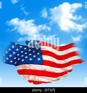 Main numérique, le toucher, l'enveloppa avec le drapeau américain, isolé contre le ciel bleu nuageux Banque D'Images