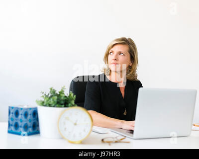 Pensive young woman in office Banque D'Images