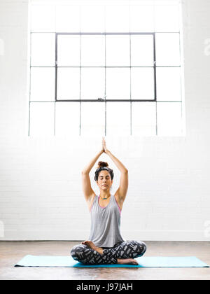 Woman sitting on exercise mat Banque D'Images