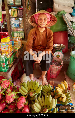 Femme avec produire peut caler au marché Duoc, Province de Long An, Delta du Mekong, Vietnam Banque D'Images