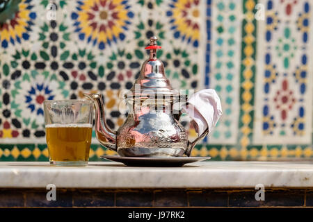 Théière marocaine contre les tuiles traditionnelles Banque D'Images