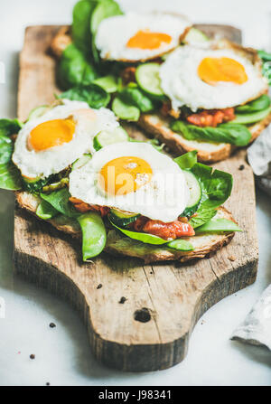 Toasts de pain avec les œufs et les légumes frais à bord Banque D'Images