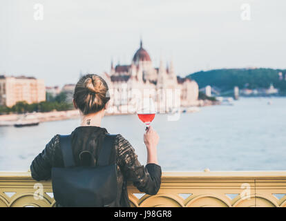 Jeune femme debout avec verre de vin rose à Budapest Banque D'Images