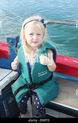 Enfant portant un gilet,s'amusant sur un voyage en bateau dans la baie de Dublin, Irlande Banque D'Images