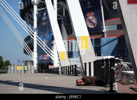 Un sans-abri dort sur le sol à l'extérieur le Stade National du Pays de Galles (aka Principauté Stadium) Banque D'Images