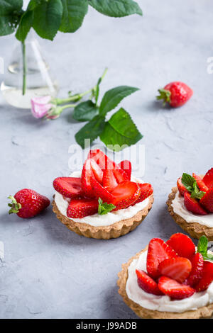 Fromage à la crème aux fraises tartelettes sur fond gris clair Banque D'Images