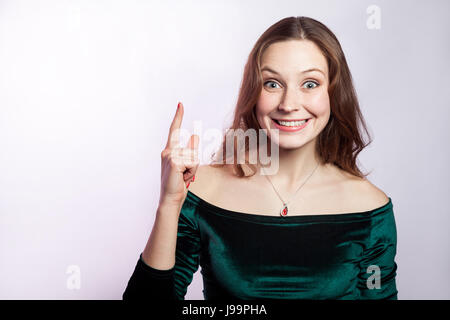 Idée est venue. Portrait de femme de merveille avec des taches de rousseur et classic robe vert. studio shot sur fond gris argent. Banque D'Images