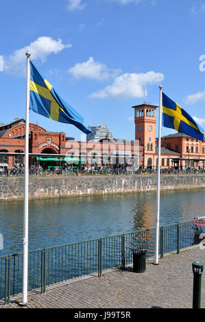 Gare centrale de Malmo, en Suède, à côté du canal Ostra Hamnkanalen, avec des drapeaux suédois et un grand nombre de vélos Banque D'Images