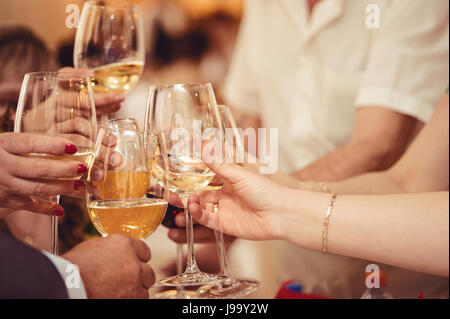 La célébration. Mains tenant les verres de champagne et vin faire un toast. Banque D'Images