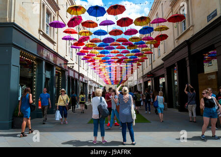 Bath, Somerset, Royaume-Uni la météo. 1er juin 2017. Les gens marchent à l'ombre sous 'Umbrella' dans la rue Belleville. Mille parapluies sont en suspension dans l'air au-dessus d'aubaines en SouthGate ramène son parapluie populaires spectacle de rue pour une deuxième année à St Lawrence Street au nord et sud de la rue Saint-Laurent. L'installation est la plus grande encore, avec trois fois plus de parapluies utilisés et l'introduction de pelouses artificielles et arbres décoratifs doublure également les rues. Photo par : Richard Wayman/Alamy Live News Banque D'Images