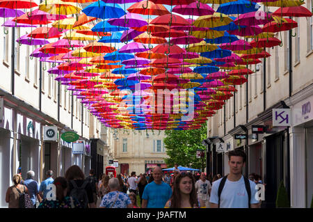 Bath, Somerset, Royaume-Uni la météo. 1er juin 2017. Les gens marchent à l'ombre sous 'Umbrella' dans la rue Belleville. Mille parapluies sont en suspension dans l'air au-dessus d'aubaines en SouthGate ramène son parapluie populaires spectacle de rue pour une deuxième année à St Lawrence Street au nord et sud de la rue Saint-Laurent. L'installation est la plus grande encore, avec trois fois plus de parapluies utilisés et l'introduction de pelouses artificielles et arbres décoratifs doublure également les rues. Photo par : Richard Wayman/Alamy Live News Banque D'Images