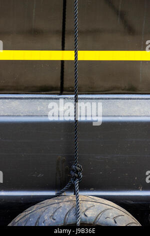 Pneu en caoutchouc fender accrochée à une corde sur une péniche amarrée sur Regent's Canal à King's Cross, Londres, UK Banque D'Images