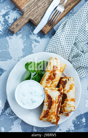 Les crêpes dans une assiette et sur une table Banque D'Images