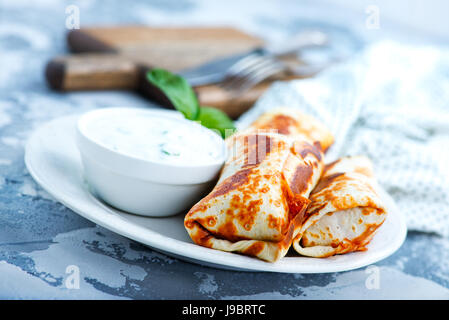 Les crêpes dans une assiette et sur une table Banque D'Images