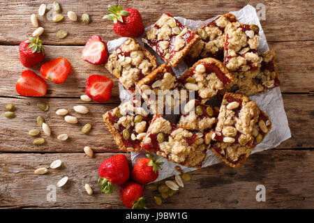 Des bars aux fraises avec du gruau, arachides et graines de citrouille sur la table horizontale vue du dessus. Banque D'Images