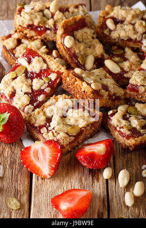 Les barres granola avec fraise, graines de tournesol et des arachides close-up sur la table verticale. Banque D'Images