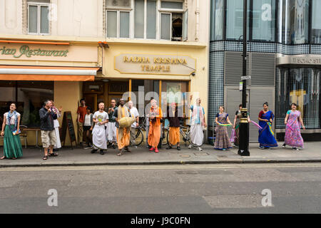 Les dévots danser et chanter à l'extérieur du Temple Radha-Krishna dans Soho Street, London, UK Banque D'Images