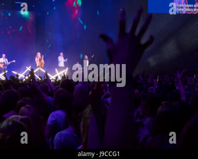 Audience avec les mains posées à un festival de musique et de lumières sur de au-dessus de la scène. Se concentrer sur les mains Banque D'Images