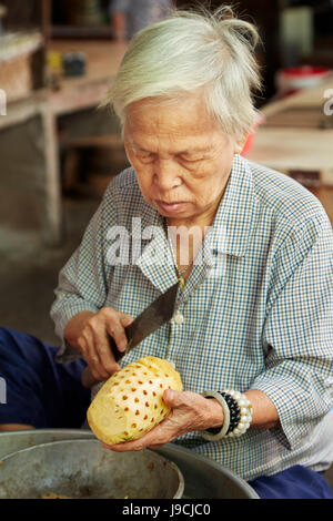 Coupe femme âgée, ananas, marché Duoc peut Province de Long An, Delta du Mékong, Vietnam Banque D'Images
