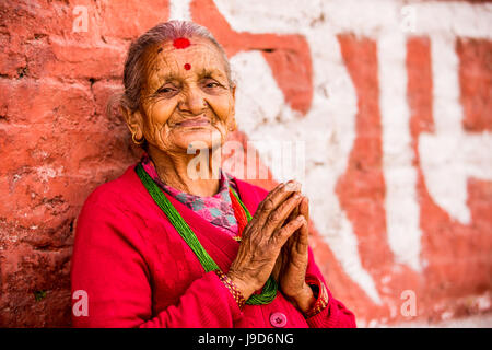 Vieille Femme en prière au temple de Pashupatinath, Katmandou, Népal, Asie Banque D'Images