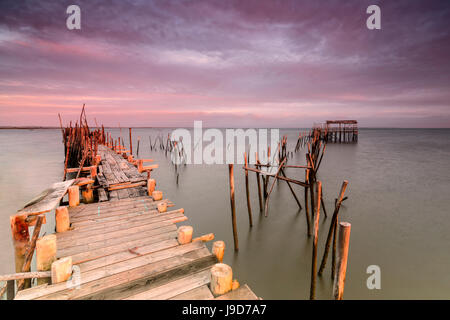 Ciel rose à l'aube sur la jetée dans la maison sur pilotis Carrasqueira Réserve naturelle du fleuve Sado, Alcacer do Sal, Setubal, Portugal Banque D'Images