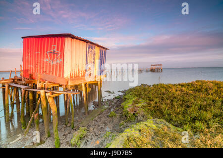 Ciel rose à l'aube sur la jetée dans la maison sur pilotis Carrasqueira Réserve naturelle du fleuve Sado, Alcacer do Sal, Setubal, Portugal Banque D'Images