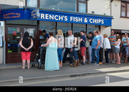 Les gens queue devant le français's Fish & Chip shop, wells-next-the-Sea, North Norfolk, Angleterre Banque D'Images