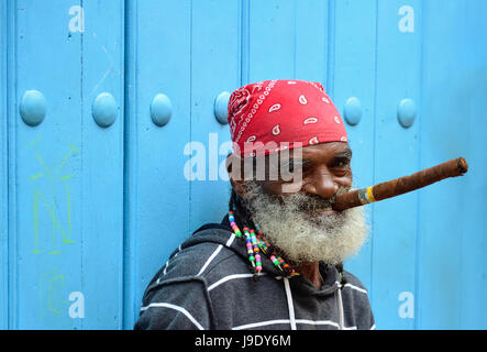 La HAVANE, CUBA - 10 décembre 2016 : l'homme cubain avec le menton posé pour des photos tout en fumant gros cigare cubain dans le centre de la vieille Havane à Cuba Banque D'Images