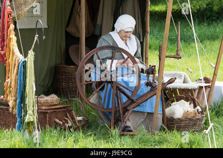 Femme filer dans un campement à un Hogan-vexel English Civil war reenactment événement. Charlton Park, Malmesbury, Wiltshire, Royaume-Uni Banque D'Images