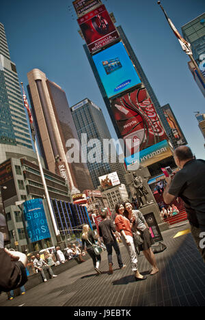 L'homme de prendre une photo de touristes sur un smartphone sur Times Square, New York Banque D'Images