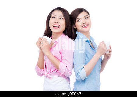 Cheerful asian female friends holding tasses à café bénéficiant d'une conversation Banque D'Images