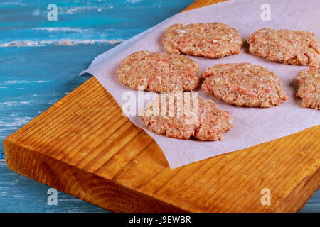 Burger de viande de boeuf haché cru escalopes steak avec assaisonnement sur planches de bois vintage, vue du dessus Banque D'Images