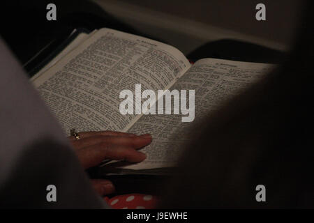 Close up of Bible ouverte sur les genoux de femme Banque D'Images