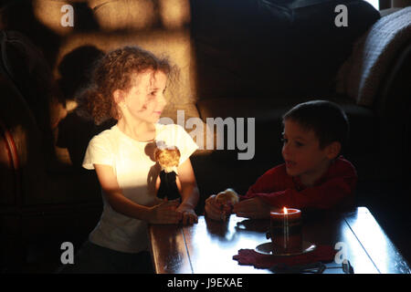 Deux enfants jouant avec des poupées à l'intérieur Banque D'Images